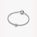 Silver bracelet with a peace symbol charm on a light background