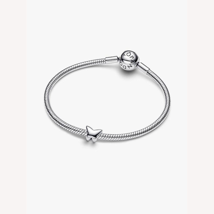 Silver bracelet with a butterfly shaped charm on a light background