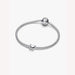 Silver bracelet with a butterfly shaped charm on a light background