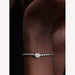 Silver bracelet with a small round clasp on a wrist