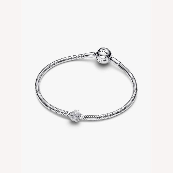 Silver bracelet with a small round charm on a white background