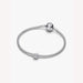 Silver bracelet with a small round charm on a white background