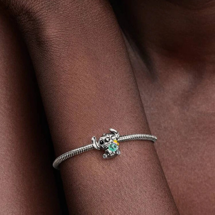 A woman wearing a bracelet featuring a turtle charm on her wrist.