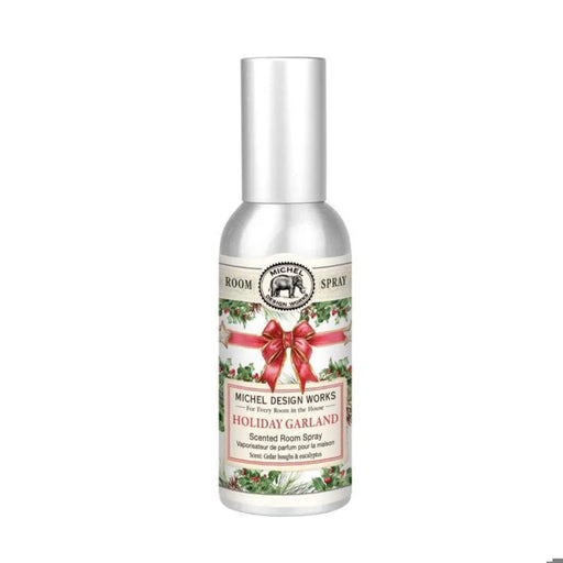 Michel Design Works Holiday Garland room spray in a silver bottle with a silver cap, green holiday foliage, red berries, and a red ribbon bow.