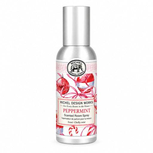 Michel Design Works Peppermint scented room spray in a silver bottle with a tall silver cap and a festive label featuring red ornaments, striped candy canes, and pink ribbon.