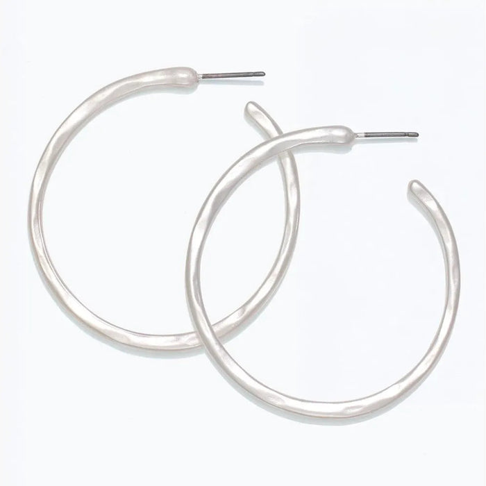 Periwinkle hammered silver hoop earrings with a textured matte finish and classic circular design.