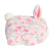 A soft, spotted bunny toy in pink and blue, featuring a smiling face and long, floppy ears.