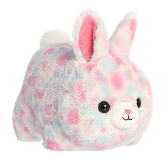 A plush bunny adorned with pink and blue spots, showcasing a friendly face and soft, floppy ears.