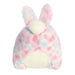 A plush bunny with playful pink and blue spots, complete with a friendly smile and floppy ears.
