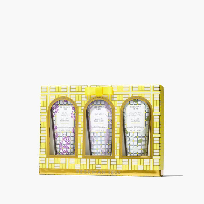 Three skincare products in a decorative yellow box on a white background