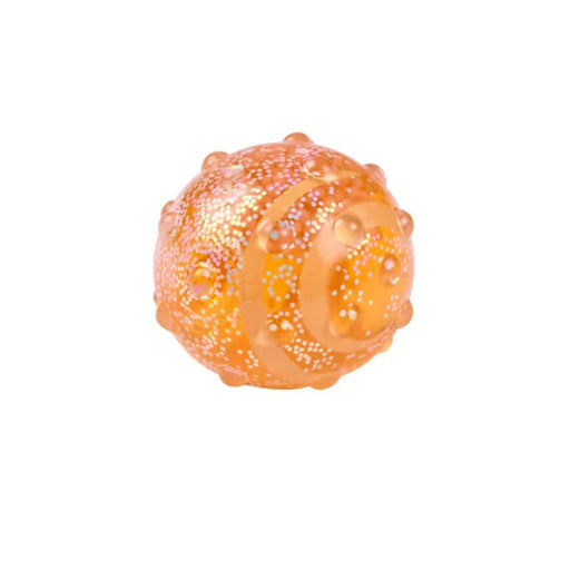 Hape Glow Squish orange translucent squishy ball with raised bumps, curved ridges, and colorful speckles.