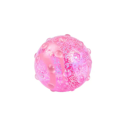 Hape Glow Squish in translucent pink with a rounded shape, raised bumps, and tiny beads inside.