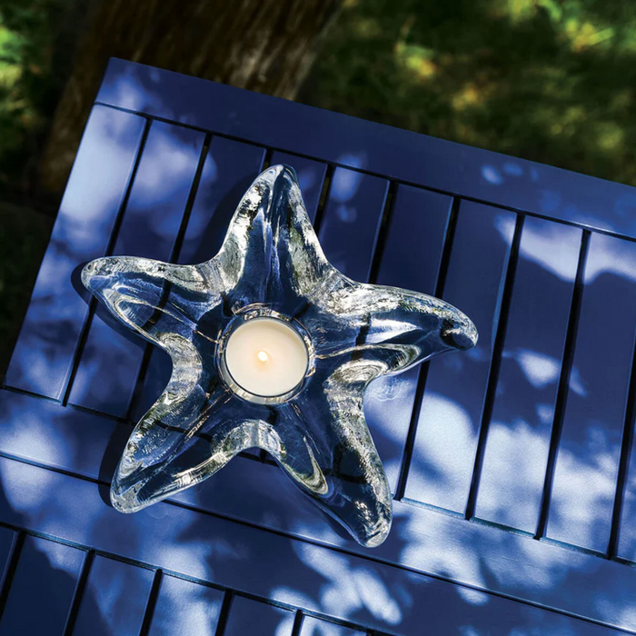 A candle positioned on a blue table, creating a tranquil atmosphere with its gentle light.