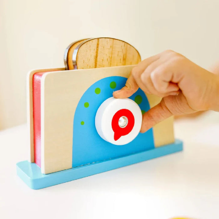 A wooden toy toaster featuring a knife, a piece of bread, and butter, perfect for pretend play.