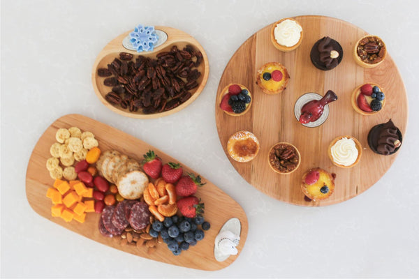 Three wooden platters with various food items on a white background