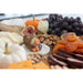 Assorted fruits, cheeses, and dried fruits on a platter with decorative elements.