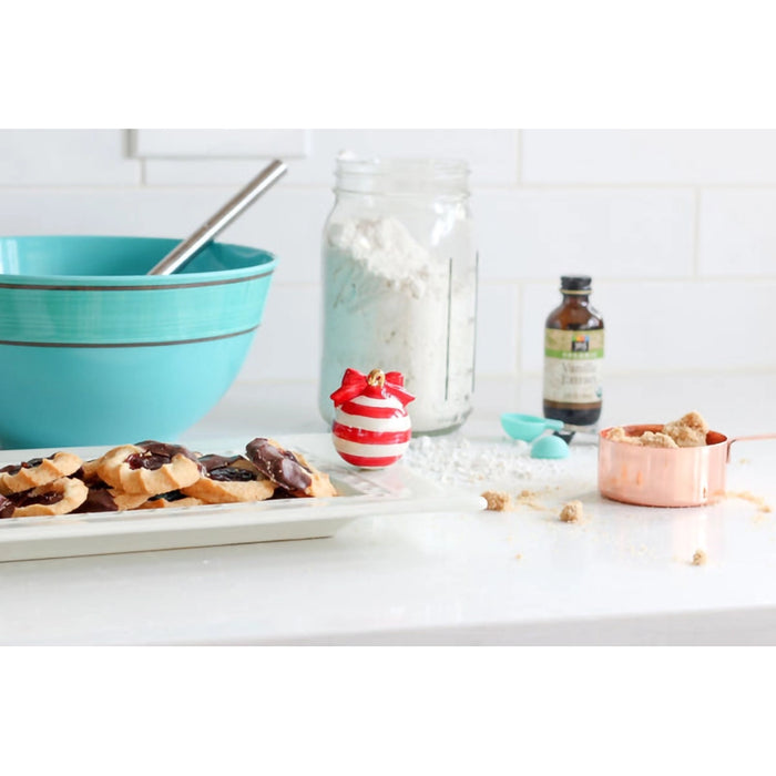 Baking ingredients and utensils on a kitchen counter with a focus on a turquoise bowl.