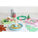 Colorful Christmas-themed play dough sets on a white surface with decorative items.