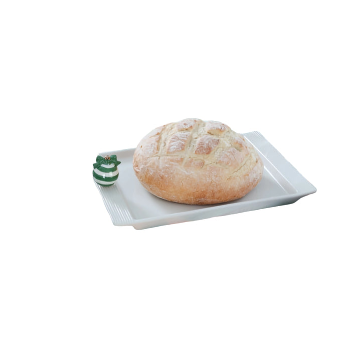 Table setting with bread on a white plate, wine glasses, and cutlery on a striped tablecloth.