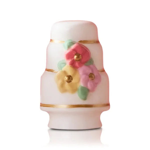 Decorative ceramic cake  Nora Fleming mini with floral designs on a white background