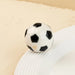 A black and white soccer ball rests on a white plate, creating a contrasting visual display.