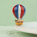 Colorful hot air balloon design on a ceramic plate with a green background