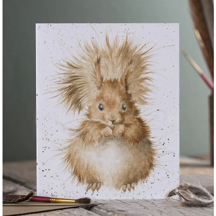 A decorative card displaying a playful squirrel, with a vibrant background of trees and foliage.