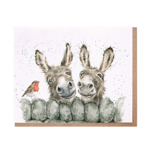Two donkeys stand on a card, with a small bird perched on top of one of them.