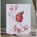 A greeting card depicting a red cardinal perched on a magnolia branch, surrounded by delicate pink flowers.