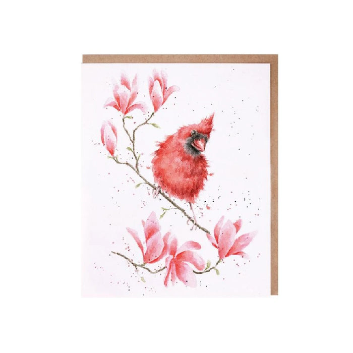 A greeting card featuring a red cardinal on a branch adorned with blooming magnolia flowers.