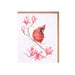 A greeting card featuring a red cardinal on a branch adorned with blooming magnolia flowers.