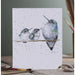 A card featuring three colorful hummingbirds perched on a branch against a soft background.