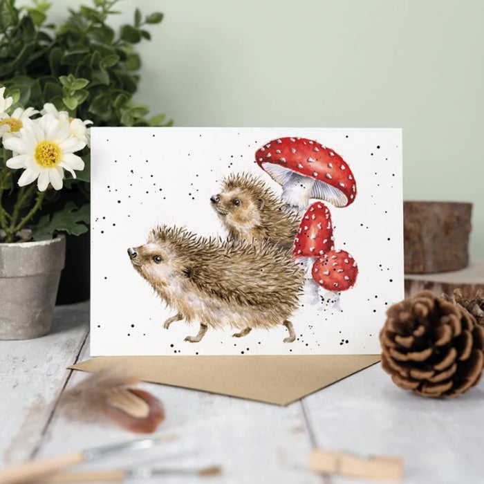 An illustrated card showing a hedgehog and a bright mushroom, capturing a delightful woodland scene.