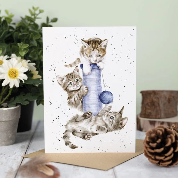A card depicting two kittens engaged in playful antics with a ball.