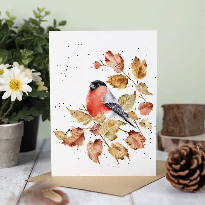 A decorative greeting card showcasing a red bird sitting on a branch, surrounded by a subtle design.