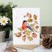 A decorative greeting card showcasing a red bird sitting on a branch, surrounded by a subtle design.
