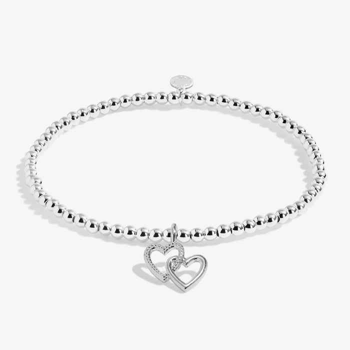 A sleek silver bracelet adorned with a charming heart pendant, perfect for adding a touch of elegance.