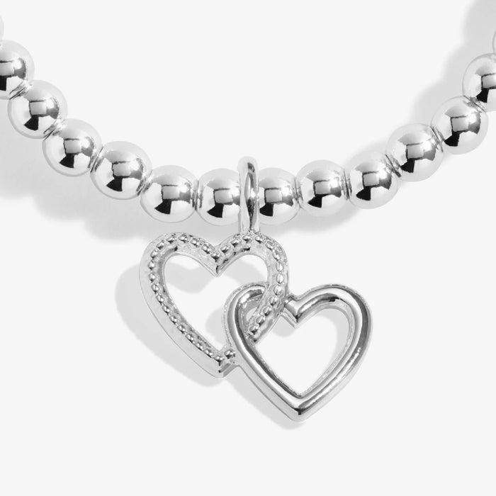 A silver bracelet with a heart charm, showcasing a simple yet elegant design suitable for any occasion.