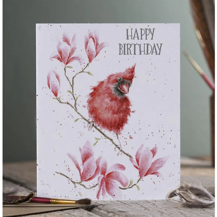 An illustration of a red bird on a branch surrounded by vibrant flowers on a card.