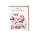 A birthday card featuring playful cats lounging on a pink couch, surrounded by colorful decorations.