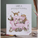 A whimsical birthday card showing cats on a pink couch, celebrating with vibrant colors and decorations.