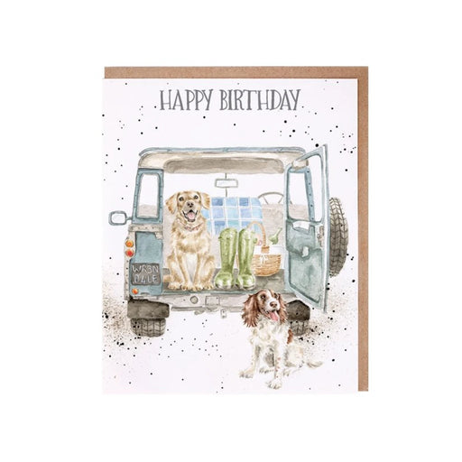 A card featuring two dogs sitting in the back of a van, looking out with playful expressions.