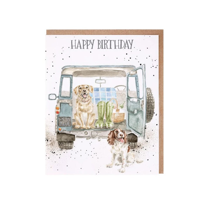 A card featuring two dogs sitting in the back of a van, looking out with playful expressions.
