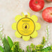 Yellow sponge with 'Spongelle' branding on a textured surface with apples and flowers.