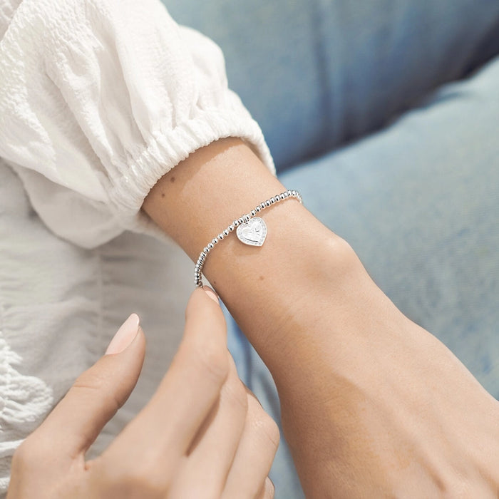 A Littles & Co Friendship Knows No Distance bracelet worn on wrist, silver beaded bracelet with heart charm for long distance friendship