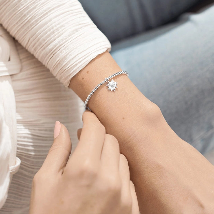 Silver beaded A Littles & Co. Happy Retirement bracelet worn on wrist with sunburst charm