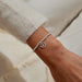 A Littles & Co. So Lucky To Have You silver beaded heart charm bracelet worn on wrist
