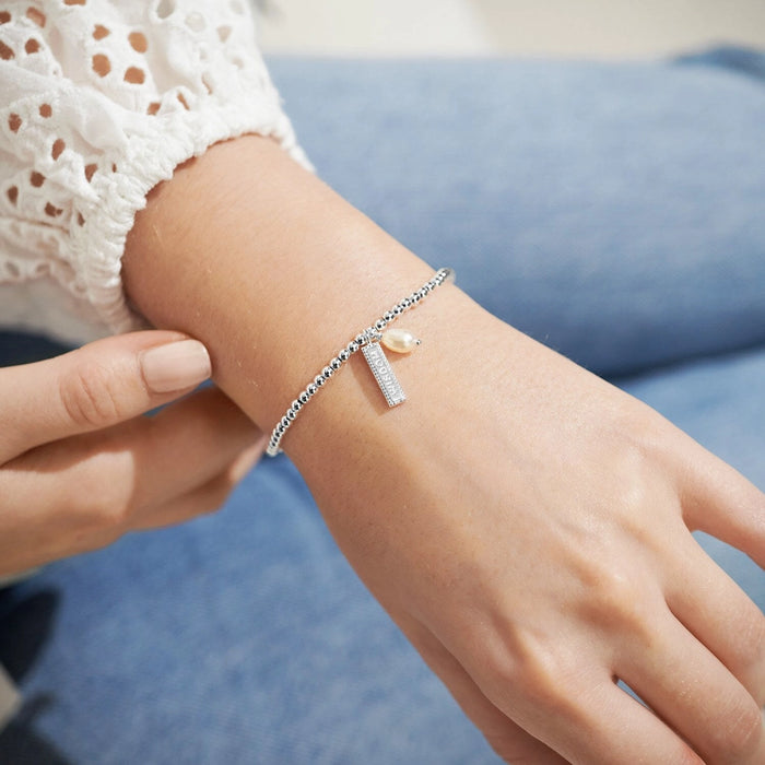 A Littles & Co A Little Wisdom silver beaded bracelet worn on wrist with wisdom charm and pearl detail
