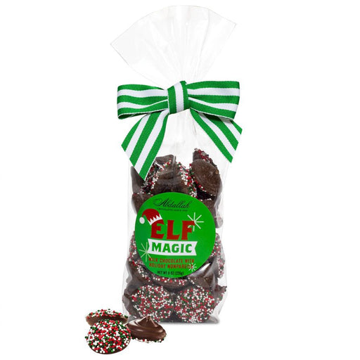 Bag of Abdallah Candies Elf Magic Milk Chocolate Non-Pareils decorated with a green striped bow and holiday sprinkles.