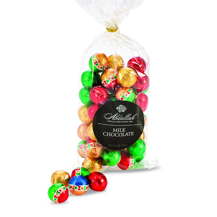 Bag of Abdallah Candies Holiday Milk Chocolate Foiled Balls in festive red, green, and gold wrappers with a few chocolates displayed in front.